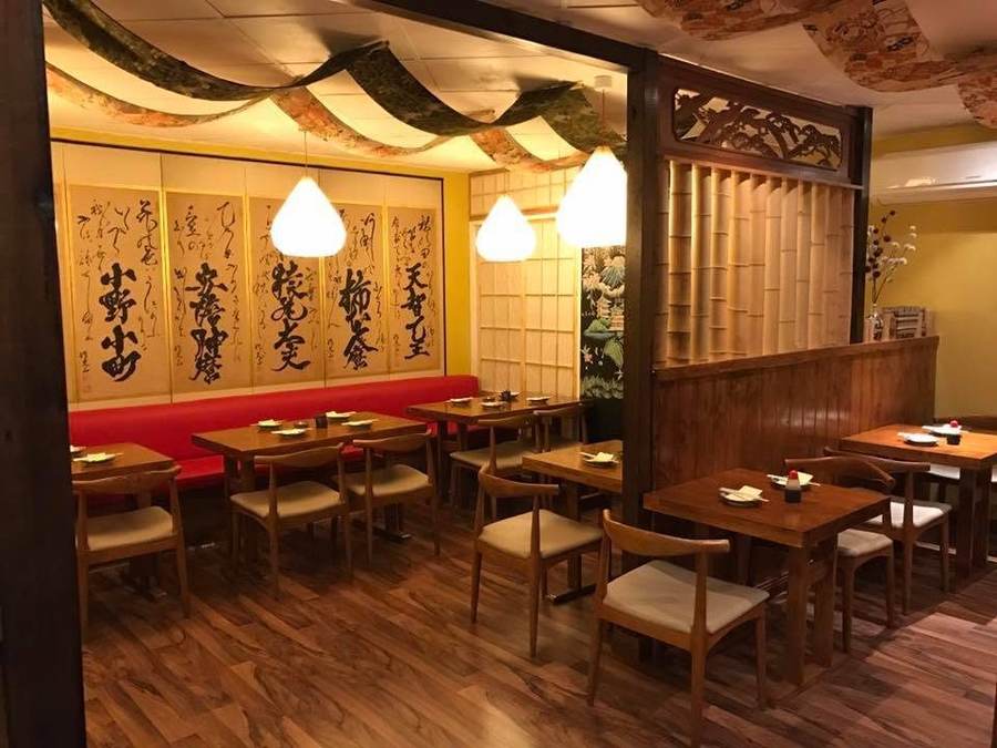 Dining room with gold calligraphy panels and paper lanterns